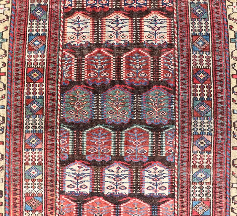 Measures: 3'3 x 8'4 This stunning antique Persian Kurdish runner showcases a vibrant and intricate design, reflecting the rich tribal heritage of Kurdish craftsmanship. The rug features a series of repeated medallions, each intricately detailed wit... - Keivan Woven ArtsEMB - 22288 - 26124Rug
