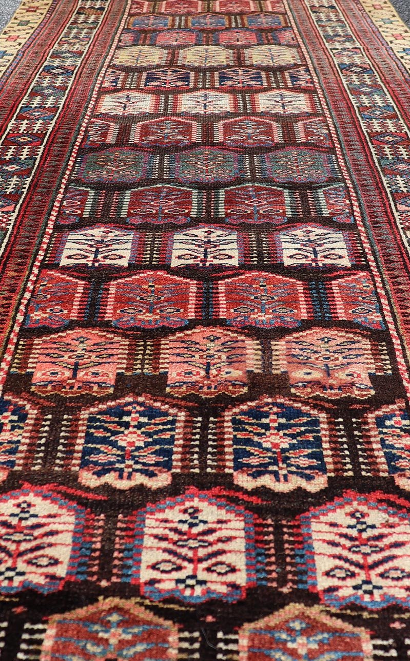 Measures: 3'3 x 8'4 This stunning antique Persian Kurdish runner showcases a vibrant and intricate design, reflecting the rich tribal heritage of Kurdish craftsmanship. The rug features a series of repeated medallions, each intricately detailed wit... - Keivan Woven ArtsEMB - 22288 - 26124Rug