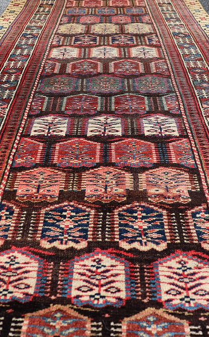 Measures: 3'3 x 8'4 This stunning antique Persian Kurdish runner showcases a vibrant and intricate design, reflecting the rich tribal heritage of Kurdish craftsmanship. The rug features a series of repeated medallions, each intricately detailed wit... - Keivan Woven ArtsEMB - 22288 - 26124Rug