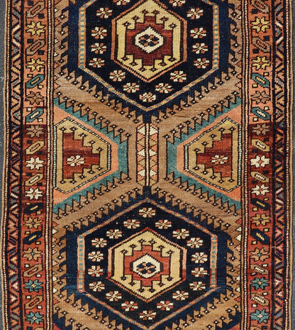 Antique Persian Kurdish Short Runner on Geometric Motifs in Light Camel Field. Medallion design on camel field, with dark blue medallions, green, red, blue , rug EMB - 8546 - 178695, country of origin / type: Iran / Hamedan, circa 1910 This ... - Keivan Woven ArtsEMB - 8546 - 178695 - 13812Rug