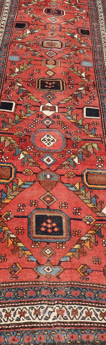 Kurdish Antique Runner in Vibrant Red Background and Multi - tiered Border This early 20th century antique Kurdish runner features a triple - lined floral border, emboldening an ivory stripe between two blue edges. The field features a tribal, sub - g... - Keivan Woven ArtsEMB - 9523 - P13064 - 14668Rug