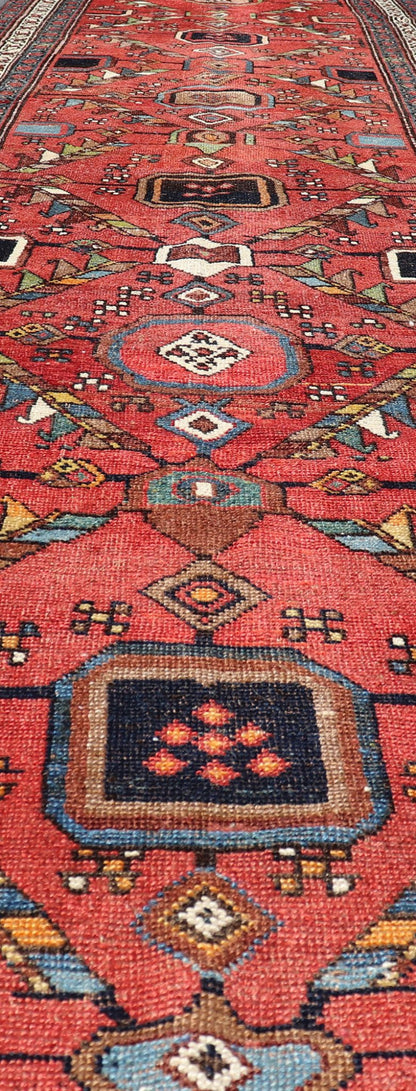 Kurdish Antique Runner in Vibrant Red Background and Multi - tiered Border This early 20th century antique Kurdish runner features a triple - lined floral border, emboldening an ivory stripe between two blue edges. The field features a tribal, sub - g... - Keivan Woven ArtsEMB - 9523 - P13064 - 14668Rug