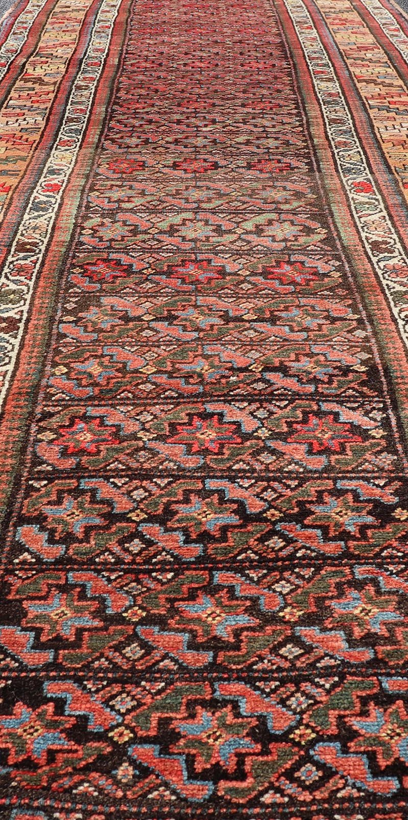 Antique Kurdish Runner with All - Over Geometric Design on A Blue Background Measures: 3'9 x 13'7 This antique runner from Persia features geometric tribal star motifs in a blue background, with accent colors of red, blue, green, and ... - Keivan Woven ArtsEMB - 9526 - P13054 - 14686Rug