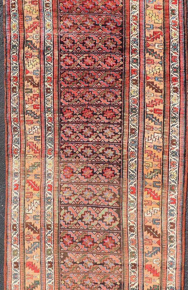 Antique Kurdish Runner with All - Over Geometric Design on A Blue Background Measures: 3'9 x 13'7 This antique runner from Persia features geometric tribal star motifs in a blue background, with accent colors of red, blue, green, and ... - Keivan Woven ArtsEMB - 9526 - P13054 - 14686Rug