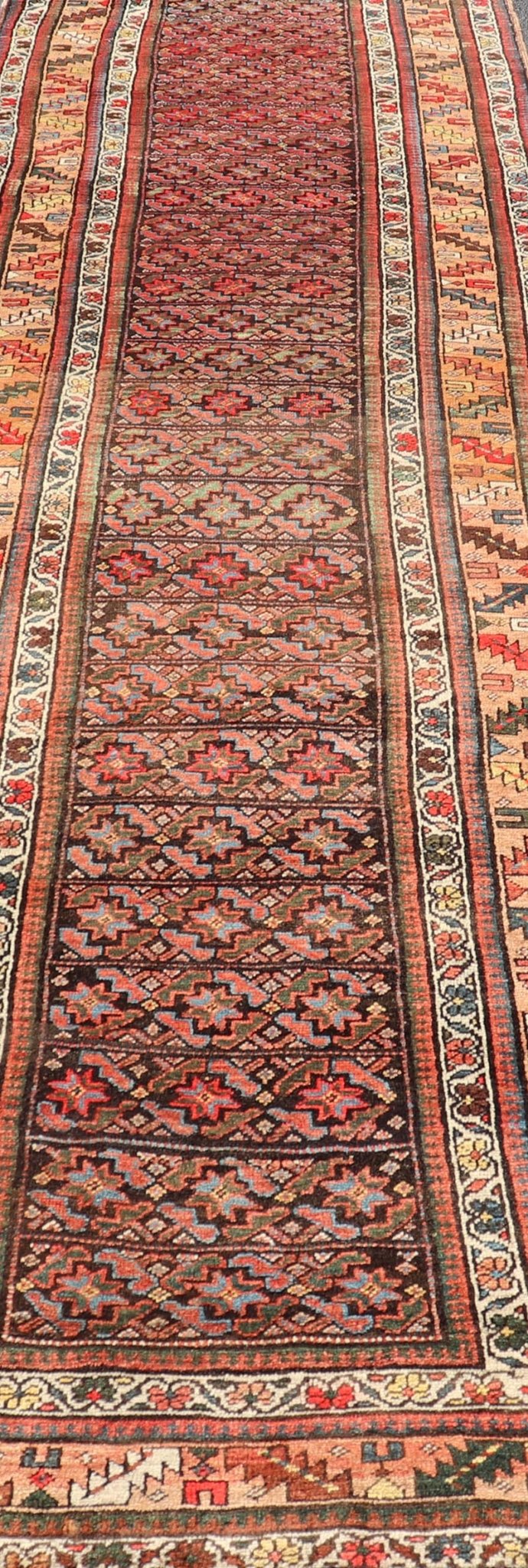 Antique Kurdish Runner with All - Over Geometric Design on A Blue Background Measures: 3'9 x 13'7 This antique runner from Persia features geometric tribal star motifs in a blue background, with accent colors of red, blue, green, and ... - Keivan Woven ArtsEMB - 9526 - P13054 - 14686Rug