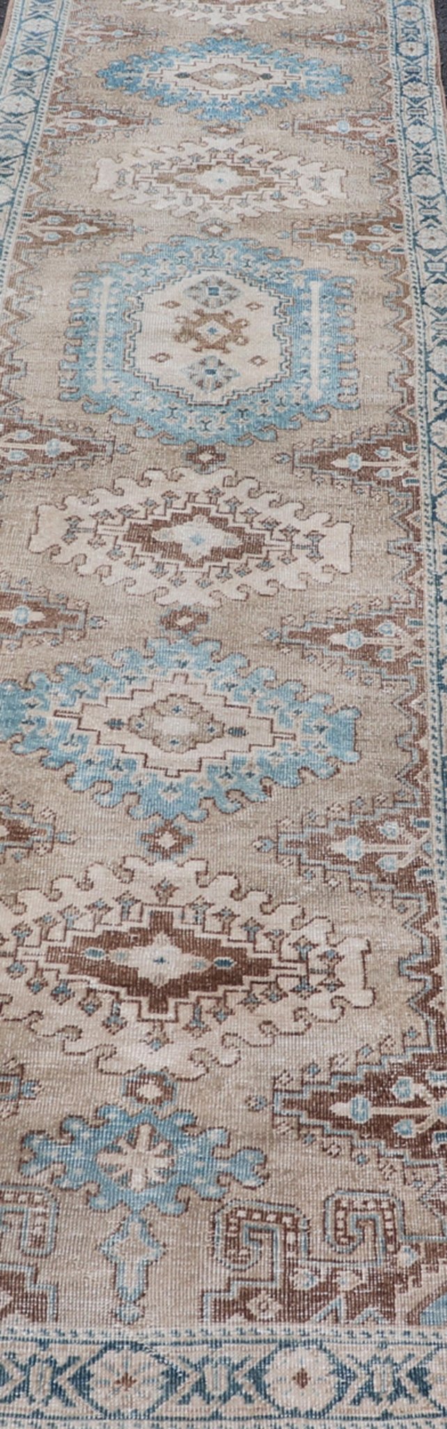 Long Hand - Knotted Antique Heriz Runner in Wool with Sub - Geometric Medallions This antique Persian Heriz runner features a sub - geometric medallion design rendered in blue, tan, brown and cream tones, set upon a tan background. A complementary, m... - Keivan Woven ArtsEMB - 9563 - P13884 - 14910Rug