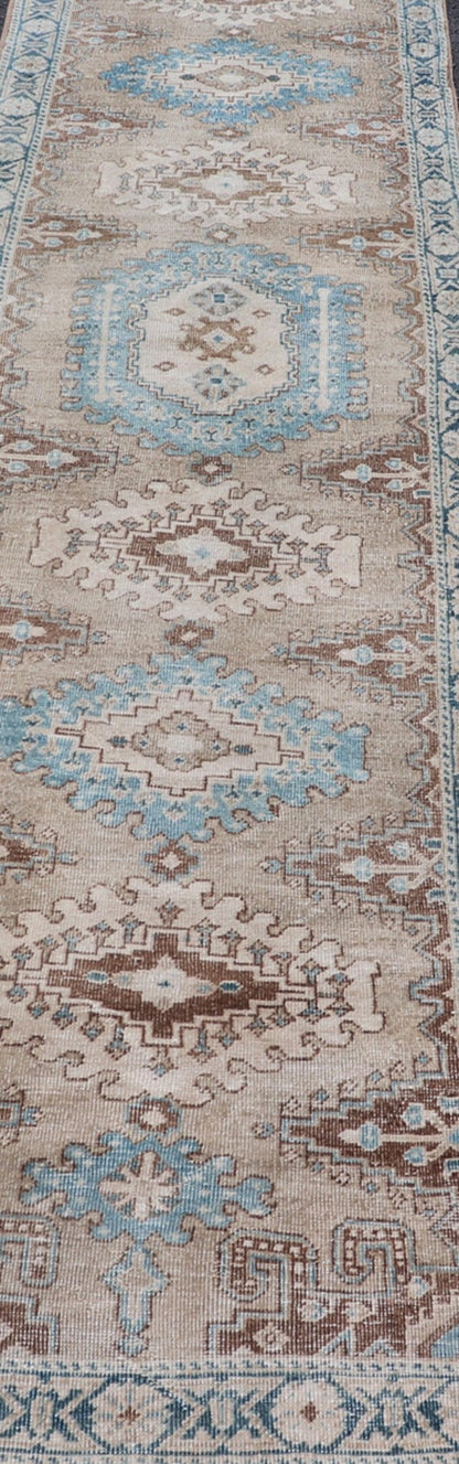 Long Hand - Knotted Antique Heriz Runner in Wool with Sub - Geometric Medallions This antique Persian Heriz runner features a sub - geometric medallion design rendered in blue, tan, brown and cream tones, set upon a tan background. A complementary, m... - Keivan Woven ArtsEMB - 9563 - P13884 - 14910Rug