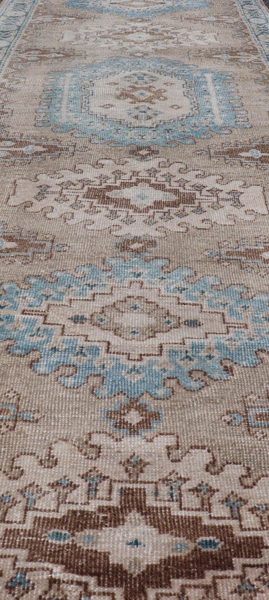 Long Hand - Knotted Antique Heriz Runner in Wool with Sub - Geometric Medallions This antique Persian Heriz runner features a sub - geometric medallion design rendered in blue, tan, brown and cream tones, set upon a tan background. A complementary, m... - Keivan Woven ArtsEMB - 9563 - P13884 - 14910Rug