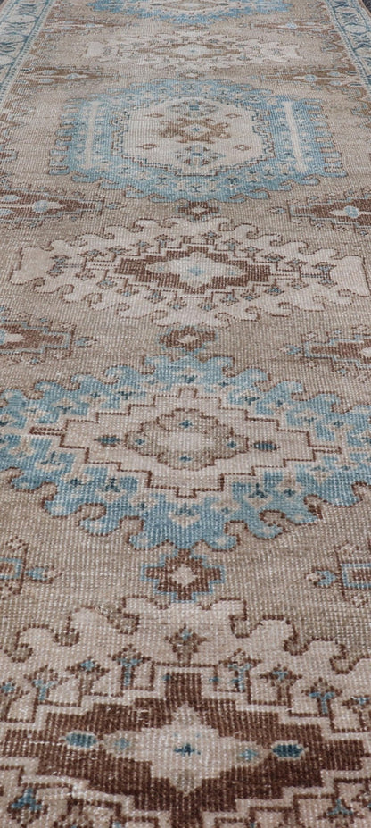 Long Hand - Knotted Antique Heriz Runner in Wool with Sub - Geometric Medallions This antique Persian Heriz runner features a sub - geometric medallion design rendered in blue, tan, brown and cream tones, set upon a tan background. A complementary, m... - Keivan Woven ArtsEMB - 9563 - P13884 - 14910Rug
