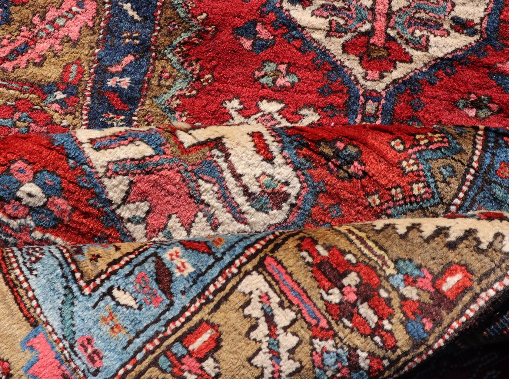 Antique Persian Heriz Runner in Reds, Blues, Pink, Ivory and Earthy Tones This gorgeous antique Persian Heriz runner features a red background imbued with ornate medallions running along the piece. Sub - geometric designs decorate the field, and a... - Keivan Woven ArtsEMB - 9577 - P13510 - 15128Rug