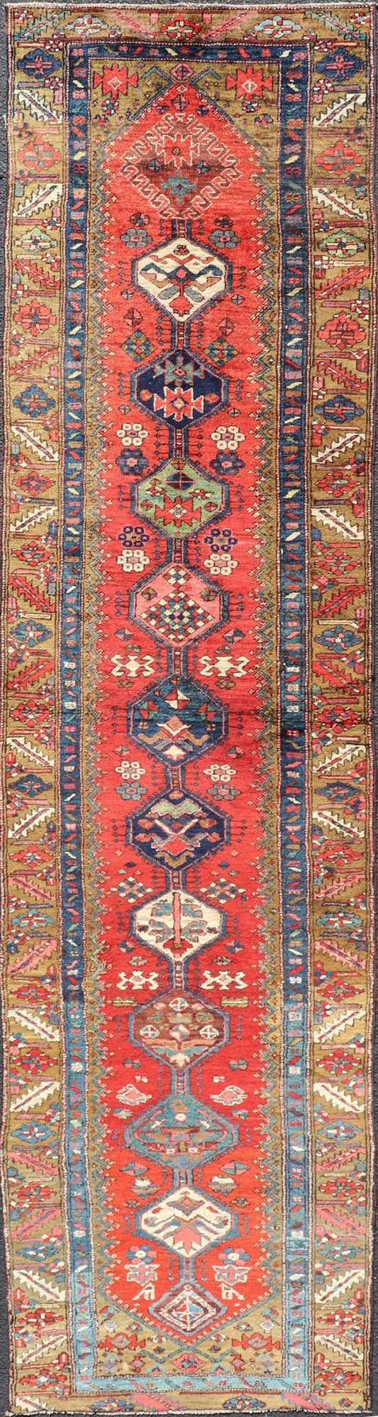 Antique Persian Heriz Runner in Reds, Blues, Pink, Ivory and Earthy Tones This gorgeous antique Persian Heriz runner features a red background imbued with ornate medallions running along the piece. Sub - geometric designs decorate the field, and a... - Keivan Woven ArtsEMB - 9577 - P13510 - 15128Rug