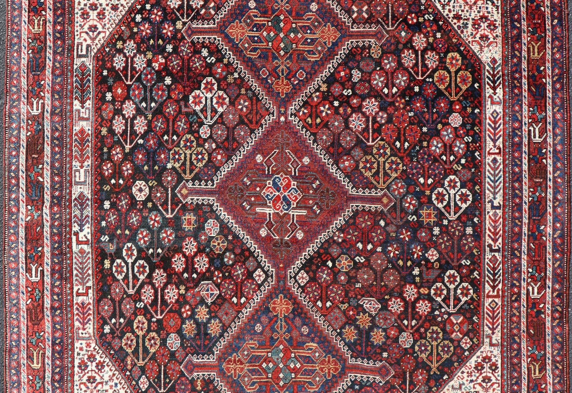 Antique Hand - Knotted Persian Qashqai Rug in Wool with All - Over Tribal Design This antique Persian Qashqai rug has been hand - knotted in wool and features an all - over sub - geometric design rendered in multicolor. A complementary, multi - tiered borde... - Keivan Woven ArtsEMB - 9628 - P13856 - 16007Rug