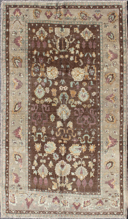 Vintage Turkish Oushak Rug in Brown Background with All - Over Floral Design Measures: 4'5 x 8'3 This Turkish Oushak is set on a chocolate - brown background and features a light gray/taupe border. The overall palette remains cool, with accent colors... - Keivan Woven ArtsEN - 1025 - 3844Rug
