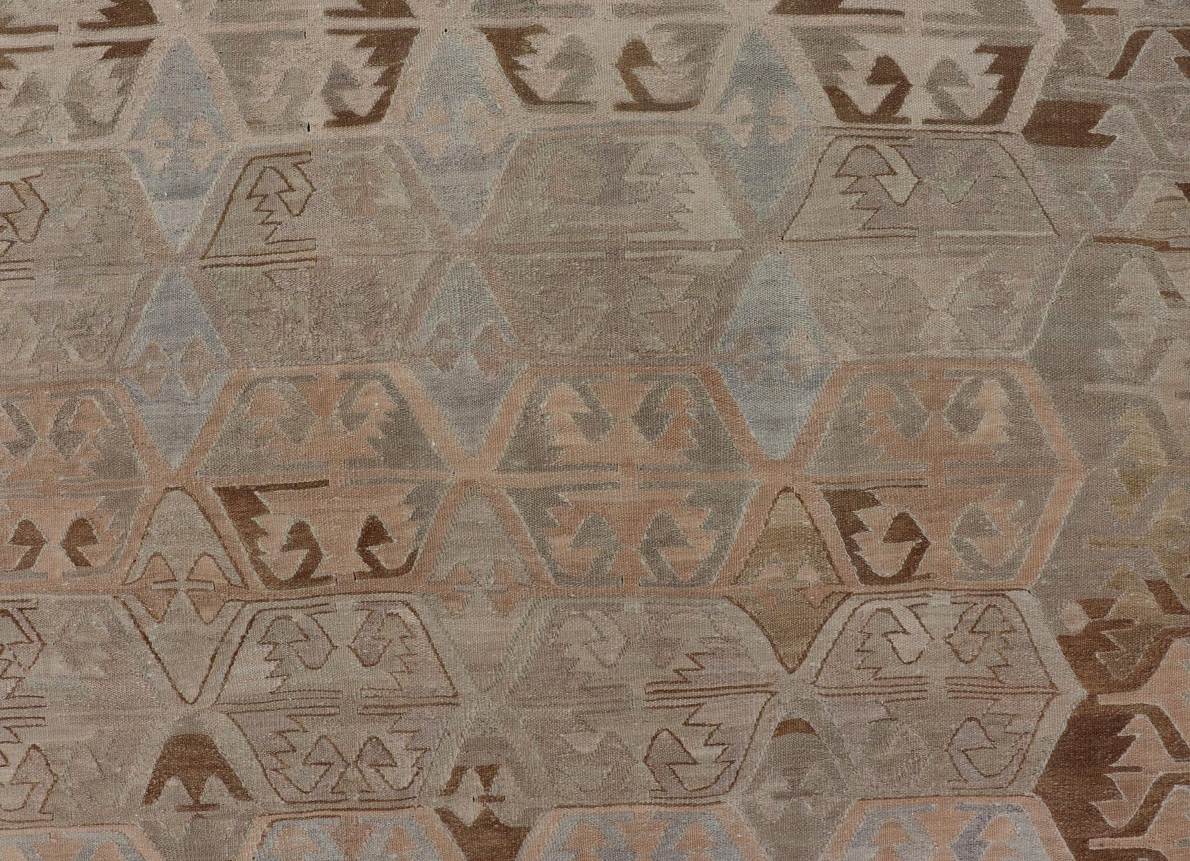 Vintage Hand - Woven Turkish Kilim Gallery Rug in Wool with Sub - Geometric Design This flat - weave tribal Turkish kilim has been hand - woven in wool. The rug features an all - over sub - geometric design, rendered in grays blues and earthy tones; making... - Keivan Woven ArtsEN - 122 - 19244