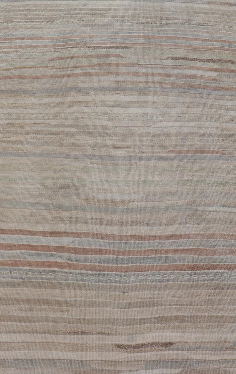 Minimalist Striped Design Vintage Turkish Kilim with Neutral Tones Measures 3'9 x 6'0 This wonderful piece features easy colors and a simple design. The palette consists of muted reds and blues, accenting the camel, fawn, and cocoa mass. ... - Keivan Woven ArtsEN - 13942 - 18926Rug