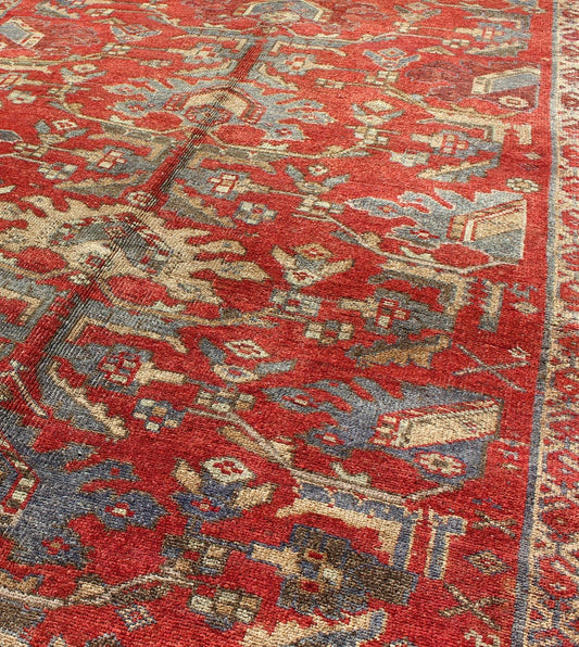 Red Turkish Oushak with Flowing Tribal Design in Red, Blue, and Gray This vintage Oushak rug features an intricate and complex design paired with a unique color combination. Flowing tribal motifs spread across the central field and are surrounde... - Keivan Woven ArtsEN - 140062 - 6027Rug