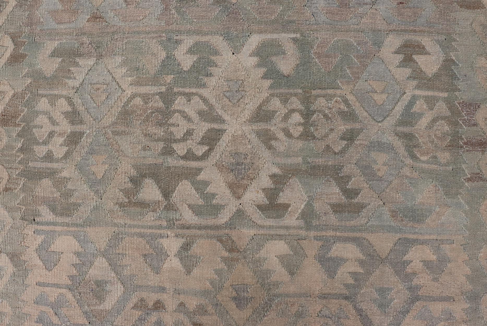 Gallery Turkish Vintage Flat - Weave Tribal Designed Kilim in Earthy Tones This vintage Turkish flat weave Kilim features tribal relics and faded earthy neutrals. The repeating design covers the entire field of muted light blue, caramel, taupe and gr... - Keivan Woven ArtsEN - 14037 - 23738Rug