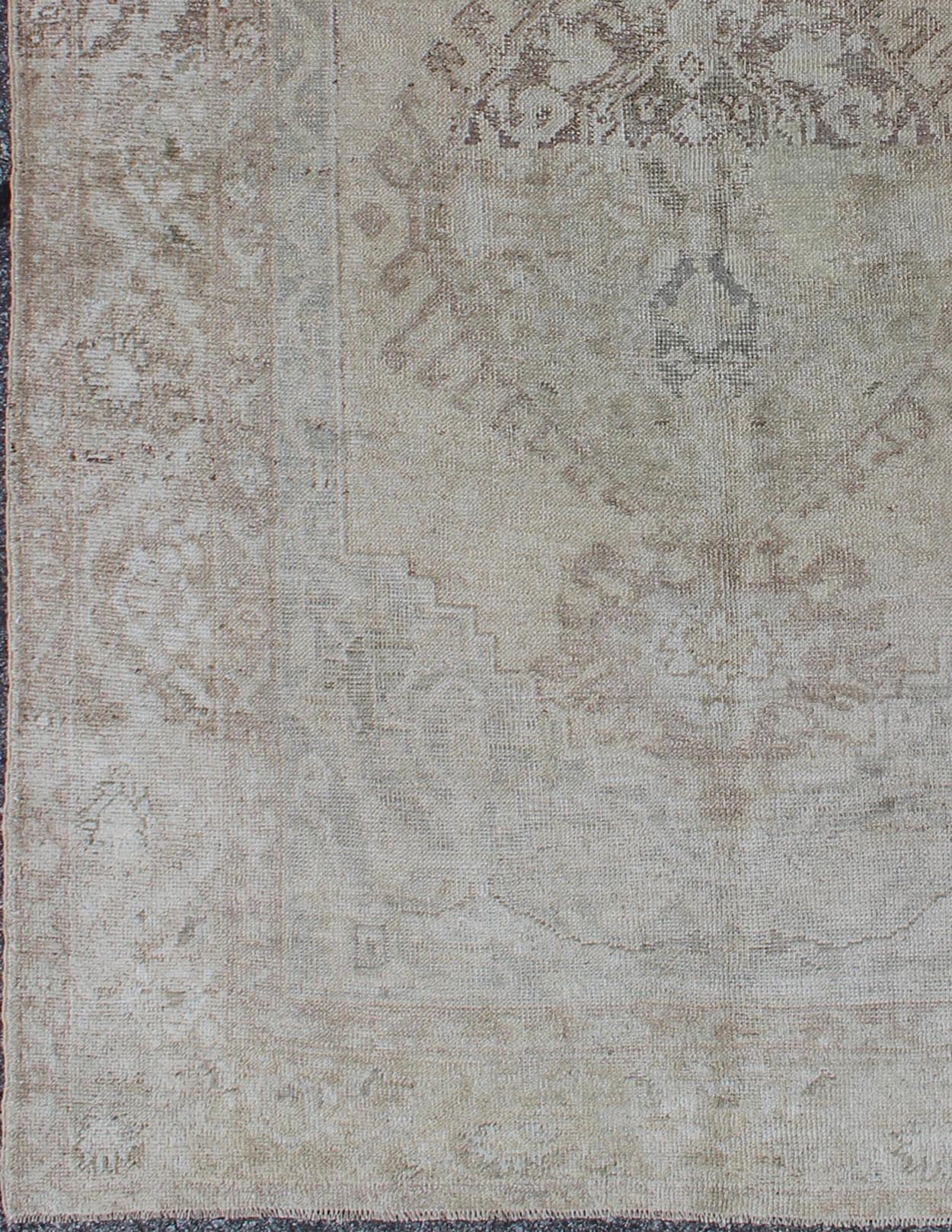 Earthy colors antique Turkish Oushak Rug with Faded Medallion Design. Vintage Oushak carpet from Turkey in earth colors, with muted neutral tones, Keivan Woven Arts / rug EN - 141385, country of origin / type: Turkey / Oushak, circa 1950. T... - Keivan Woven ArtsEN - 141385 - 6666Rug