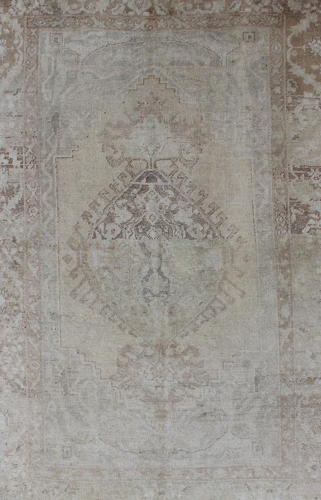 Earthy colors antique Turkish Oushak Rug with Faded Medallion Design. Vintage Oushak carpet from Turkey in earth colors, with muted neutral tones, Keivan Woven Arts / rug EN - 141385, country of origin / type: Turkey / Oushak, circa 1950. T... - Keivan Woven ArtsEN - 141385 - 6666Rug