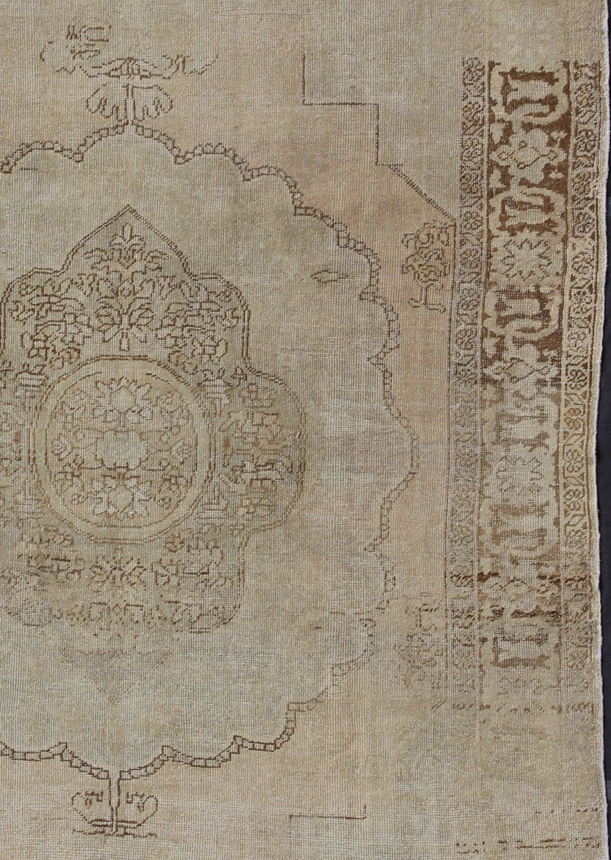 Antique Oushak Carpet in Taupe, Brown, Light Celadon Green and Neutral Colors Measures: 8'0'' x 12'1''. This antique Oushak wool rug features an over - sized medallion with detailed vines and flowers. A framework of floral motifs and styliz... - Keivan Woven ArtsEN - 141449 - 7203Rug