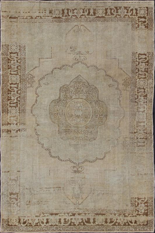 Antique Oushak Carpet in Taupe, Brown, Light Celadon Green and Neutral Colors Measures: 8'0'' x 12'1''. This antique Oushak wool rug features an over - sized medallion with detailed vines and flowers. A framework of floral motifs and styliz... - Keivan Woven ArtsEN - 141449 - 7203Rug