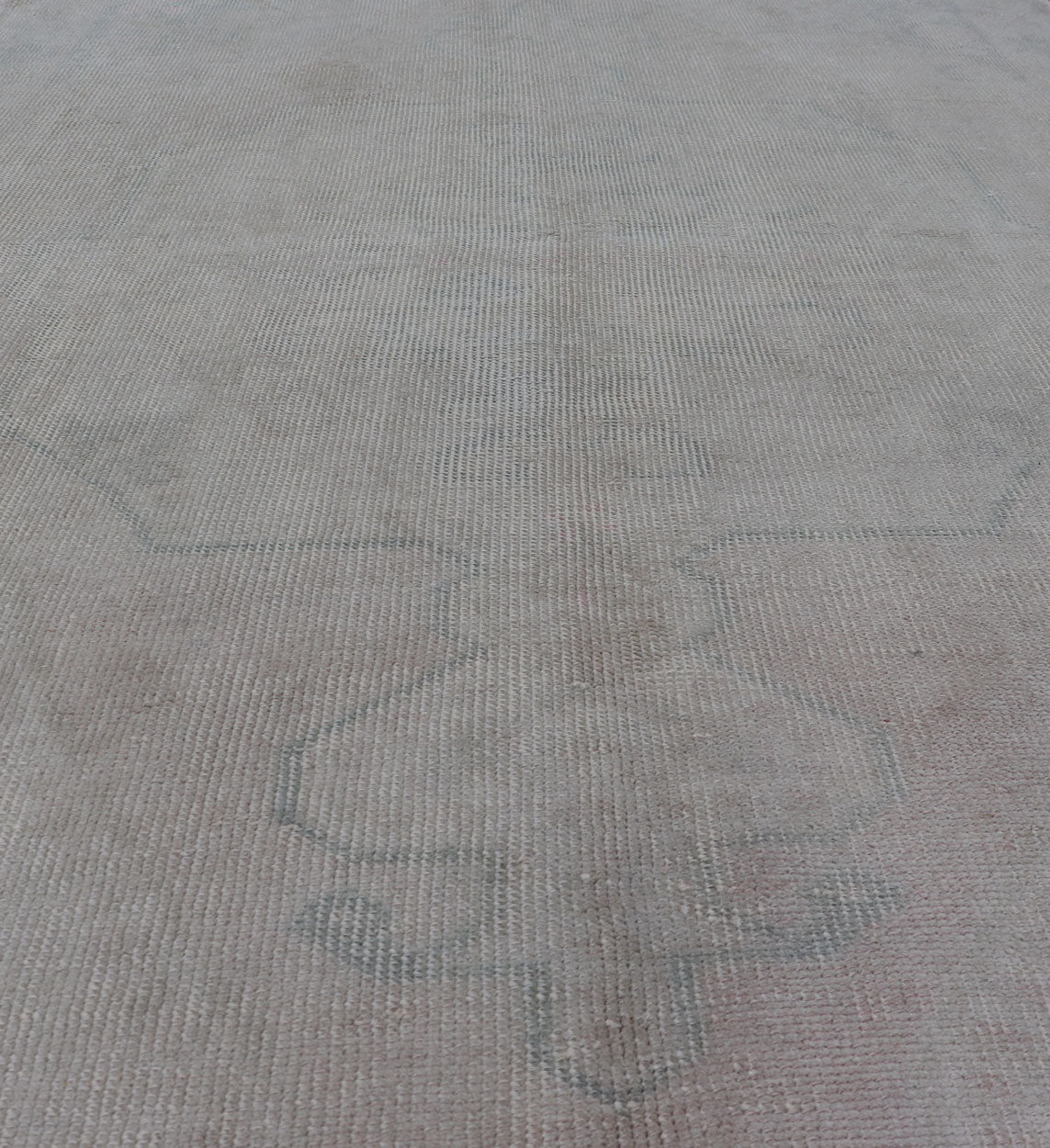 Vintage Turkish Medallion Oushak with All - Over Muted Tones of Neutral Colors Measures 4'5 x 7'0 The taupe - sandy color field homes a muted central medallion decorated in muted blue and pink. Tones of faded light green can be found within... - Keivan Woven ArtsEN - 142089 - 10940Rug
