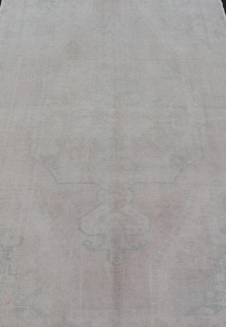 Vintage Turkish Medallion Oushak with All - Over Muted Tones of Neutral Colors Measures 4'5 x 7'0 The taupe - sandy color field homes a muted central medallion decorated in muted blue and pink. Tones of faded light green can be found within... - Keivan Woven ArtsEN - 142089 - 10940Rug