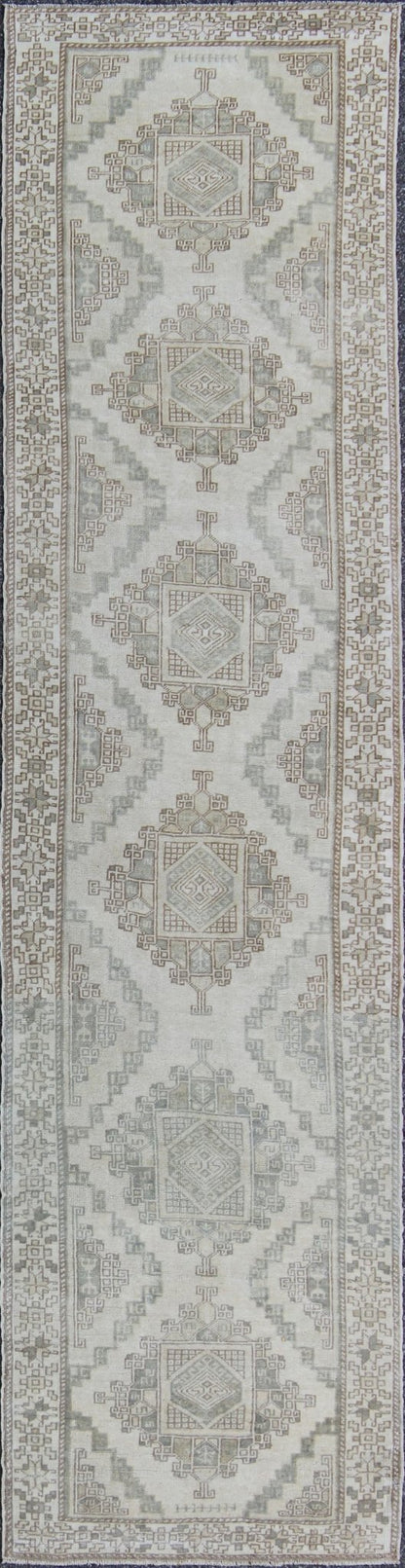 Vintage Oushak Runner with Central Medallions and Ornate Border Measures: 3'0'' x 12'3''. This beautiful vintage Oushak runner features a classic Oushak design, which is enhanced by lustrous wool. The faint ivory ground is home to six large a... - Keivan Woven ArtsEN - 142470 - 7855Rug