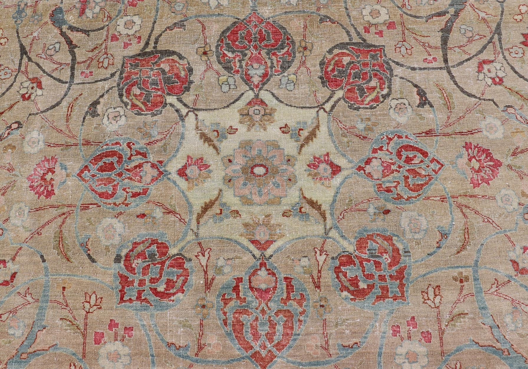 Antique Persian Tabriz Rug with Floral Medallion Design in Tan, Red, and Blue. Keivan Woven Arts / rug EN - 14861, country of origin / type: Iran / Tabriz, circa 1920 Floral Medallion Design in Tan, Red, and Blue. Measures: 8'4 x 11'9 This sublim... - Keivan Woven ArtsEN - 14861 - 23492Rug