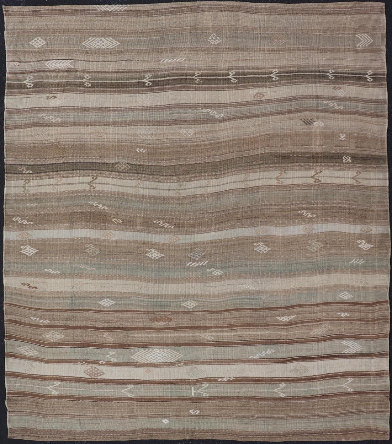 Vintage Kilim With Subtle Striped Patterns in Earth Tones Measures: 6'4" x 7'10" This Vintage Turkish Kilim showcases a flat weave with subtle patterns scattered across horizontal stripes. The kilim is decorated with shades of beige, bro... - Keivan Woven ArtsEN - 15524 - 25853Rug
