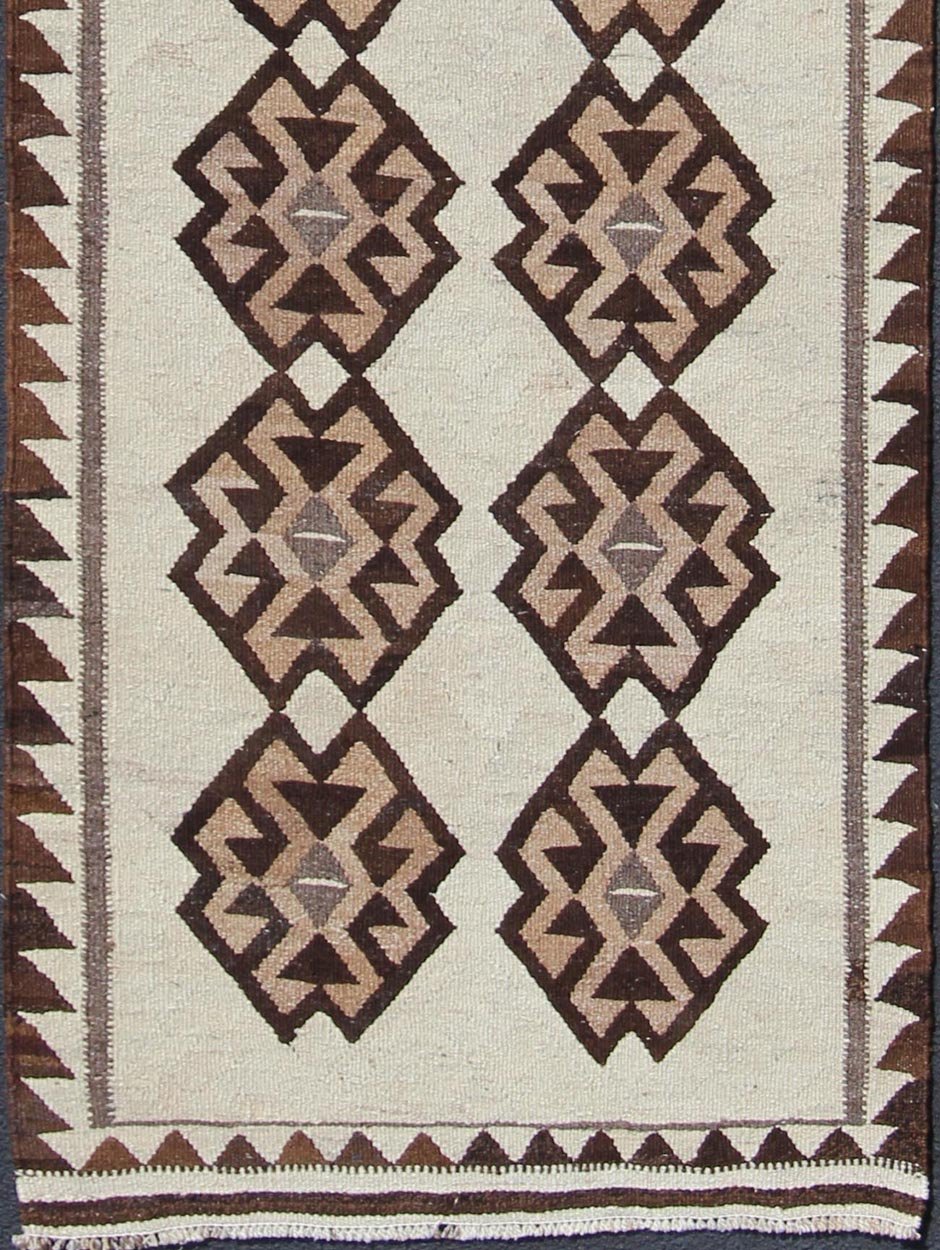 Tribal Turkish Kilim in Creams and Browns Turkish Kilim vintage runner in dark brown and cream with graphic tribal design, rug EN - 176341, country of origin / type: Turkey / Tulu, circa 1960 This unique Turkish Kilim runner features a grap... - Keivan Woven ArtsEN - 176341 - 10840Rug