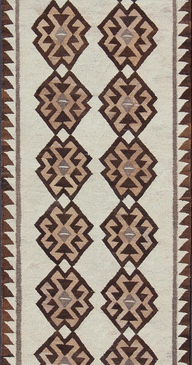 Tribal Turkish Kilim in Creams and Browns Turkish Kilim vintage runner in dark brown and cream with graphic tribal design, rug EN - 176341, country of origin / type: Turkey / Tulu, circa 1960 This unique Turkish Kilim runner features a grap... - Keivan Woven ArtsEN - 176341 - 10840Rug