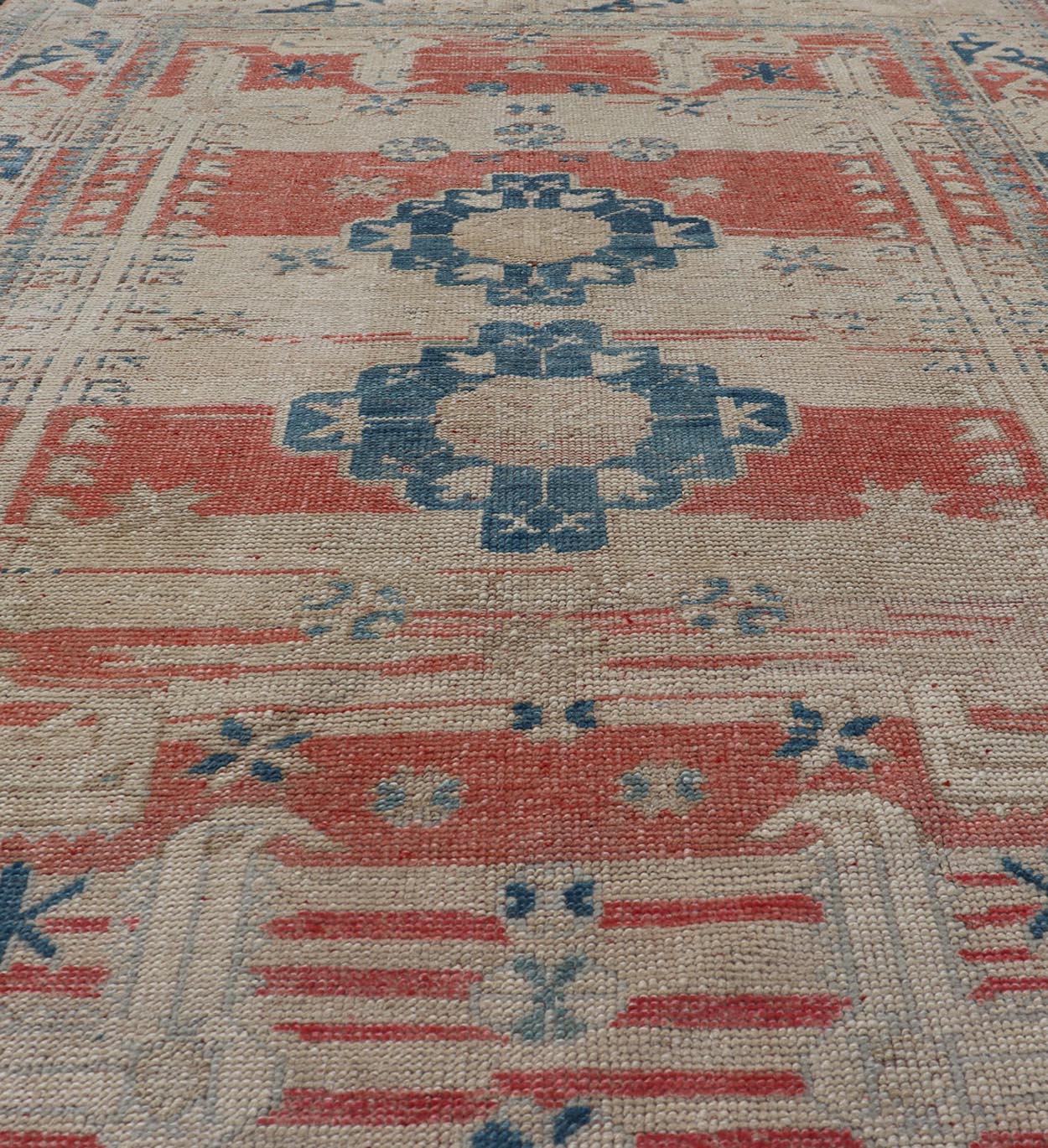 Tribal Medallion Design Vintage Turkish Oushak in Cream, Blue, and Terracotta Measures: 4'5 x 6'7 This vintage Oushak has repeating motifs in terracotta, cream, and blue encasing multiple motifs and the striped field. The eccentric fiel... - Keivan Woven ArtsEN - 178200 - 18884Rug