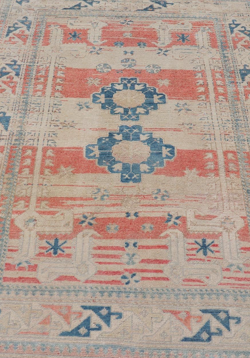 Tribal Medallion Design Vintage Turkish Oushak in Cream, Blue, and Terracotta Measures: 4'5 x 6'7 This vintage Oushak has repeating motifs in terracotta, cream, and blue encasing multiple motifs and the striped field. The eccentric fiel... - Keivan Woven ArtsEN - 178200 - 18884Rug