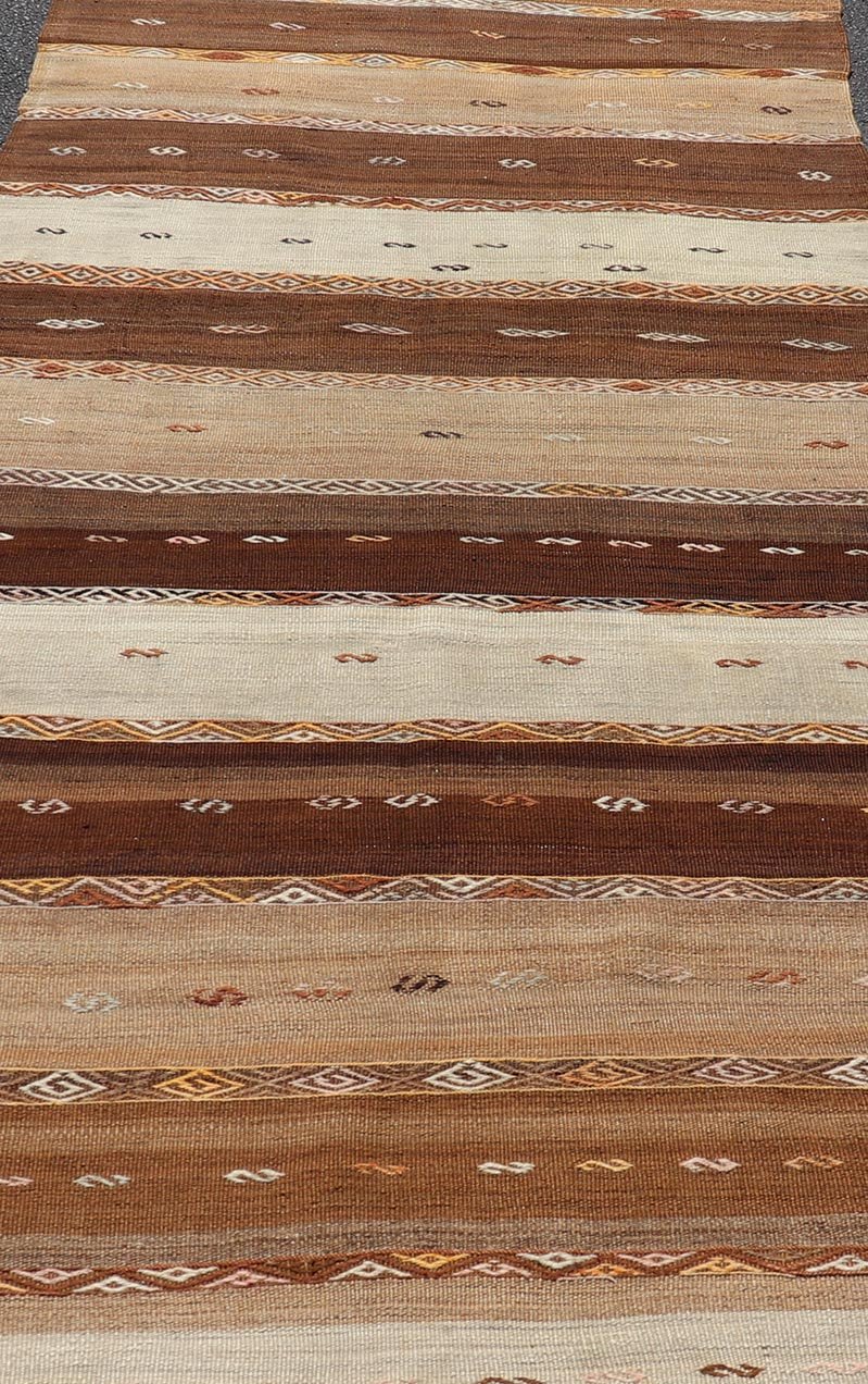 Vintage Earthy Kilim Gallery Runner with Stripe Design in Multi Colors & Motif's. Keivan Woven Arts / rug EN - 178669, country of origin / type: Turkey / Kilim, circa 1950. Measures: 4'6 x 11'7 Featuring a striking stripe design, this unique mid - c... - Keivan Woven ArtsEN - 178669 - 23504Rug