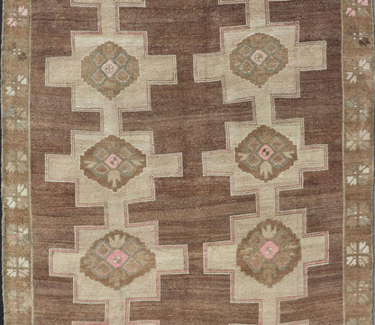 Vintage Kars Wide Gallery Rug in Brown Colors, Tan, Taupe and Light Green. Stacked in two rows of geometric medallions, this Vintage Turkish Kars wide gallery runner displays great geometry in chocolate Brown background with Colors such as Tan,... - Keivan Woven ArtsEN - 179569 - 14374Rug