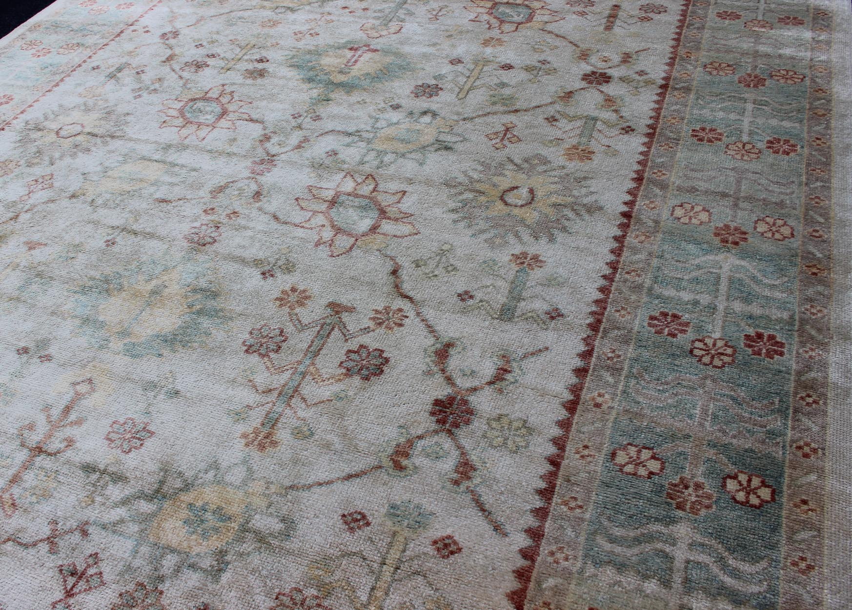 Antique Reproduction Turkish Oushak. Measures: 9'4 x 11'4. This sub geometric Oushak rug from Turkey features subdued colors in blue, light green, rust and, neutral color palette and an all - over design of floral shapes, surrounded beautifully by ... - Keivan Woven ArtsEN - 3264 - 5452