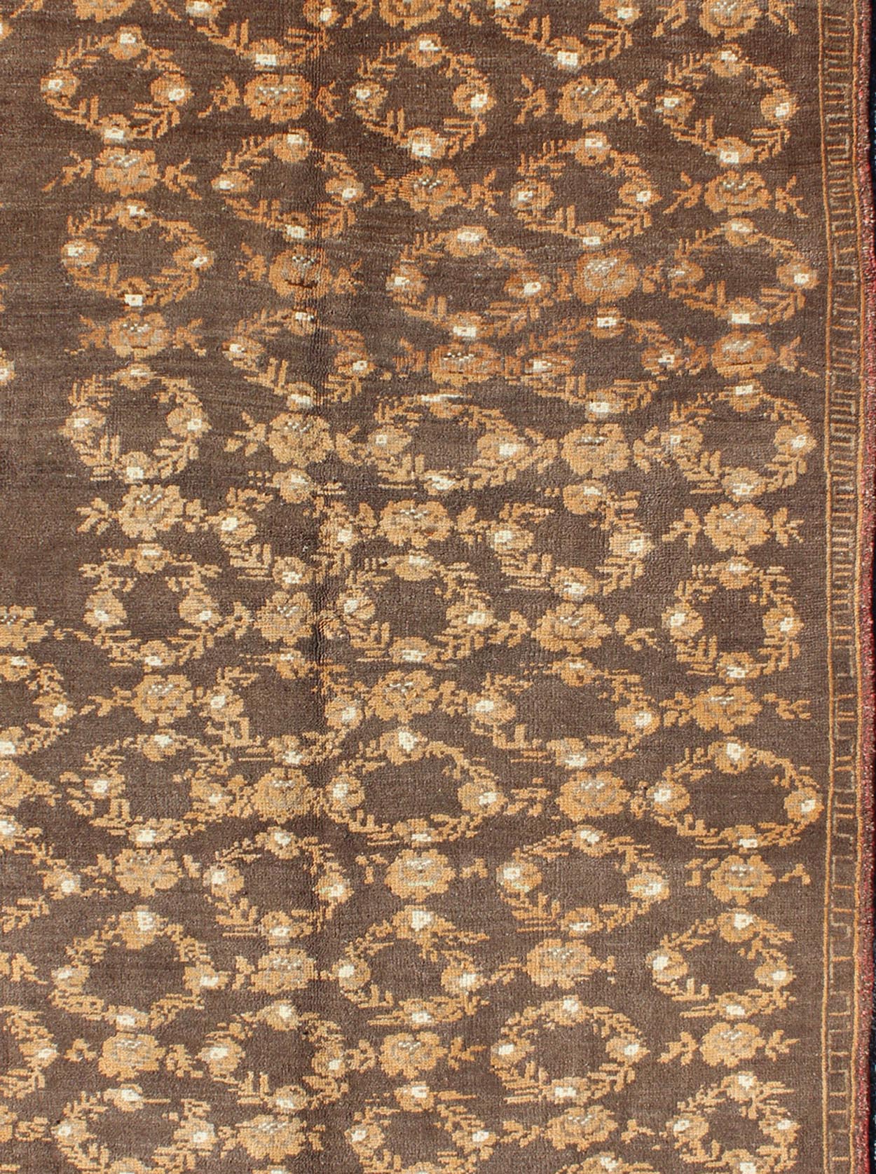 All - Over Floral Wreath Design Turkish Oushak Rug with Brown Background Measures: 4'5 x 7'4 The design of this beautiful vintage Oushak rug from mid - 20th century Turkey is enhanced by its rich colored wool. The brown ground is home to an a... - Keivan Woven ArtsEN - 534 - 3678Rug