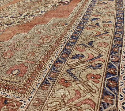 Vintage Turkish Oushak Rug This beautiful Turkish Oushak Rug has a medium blue color with a light orange background. The center medallion has earth tones with blues. The border has a rolling flower pattern. There are colors such as creamy yellow... - Keivan Woven ArtsEN - 94108 - 3158Rug
