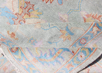 Hand - Knotted Floral Oushak Designed Rug in Light Blue, Orange, and Blue Measures 9'1 x 11'8 This wool Oushak was hand - knotted in the 2020's. The field and border both have a cool blue gray. The field and border also share floral and leaf... - Keivan Woven ArtsIN - CLR - 1002 - 13444