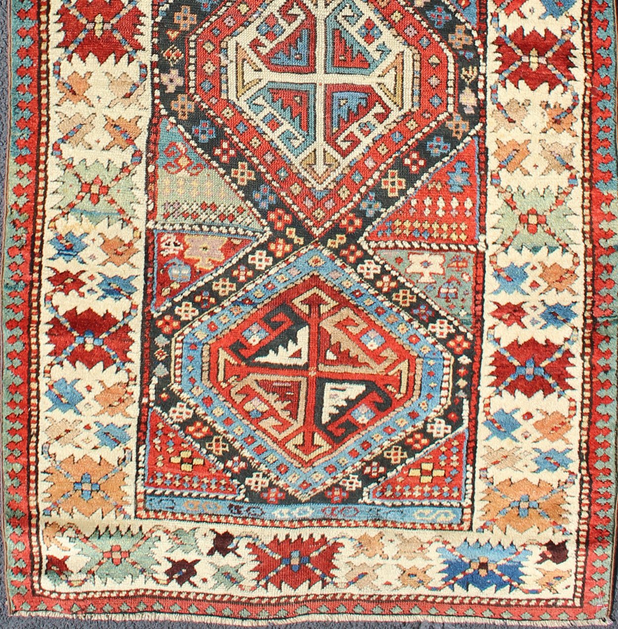 Antique Caucasian Kuba Rug This piece is an impeccable late 19th century Kuba rug with an indigo blue field beneath a geometric vinery trellis featuring bold polychrome medallions and stylized leaves. The ivory frame features repeating turtle mo... - Keivan Woven ArtsN15 - 0308 - 18Rug