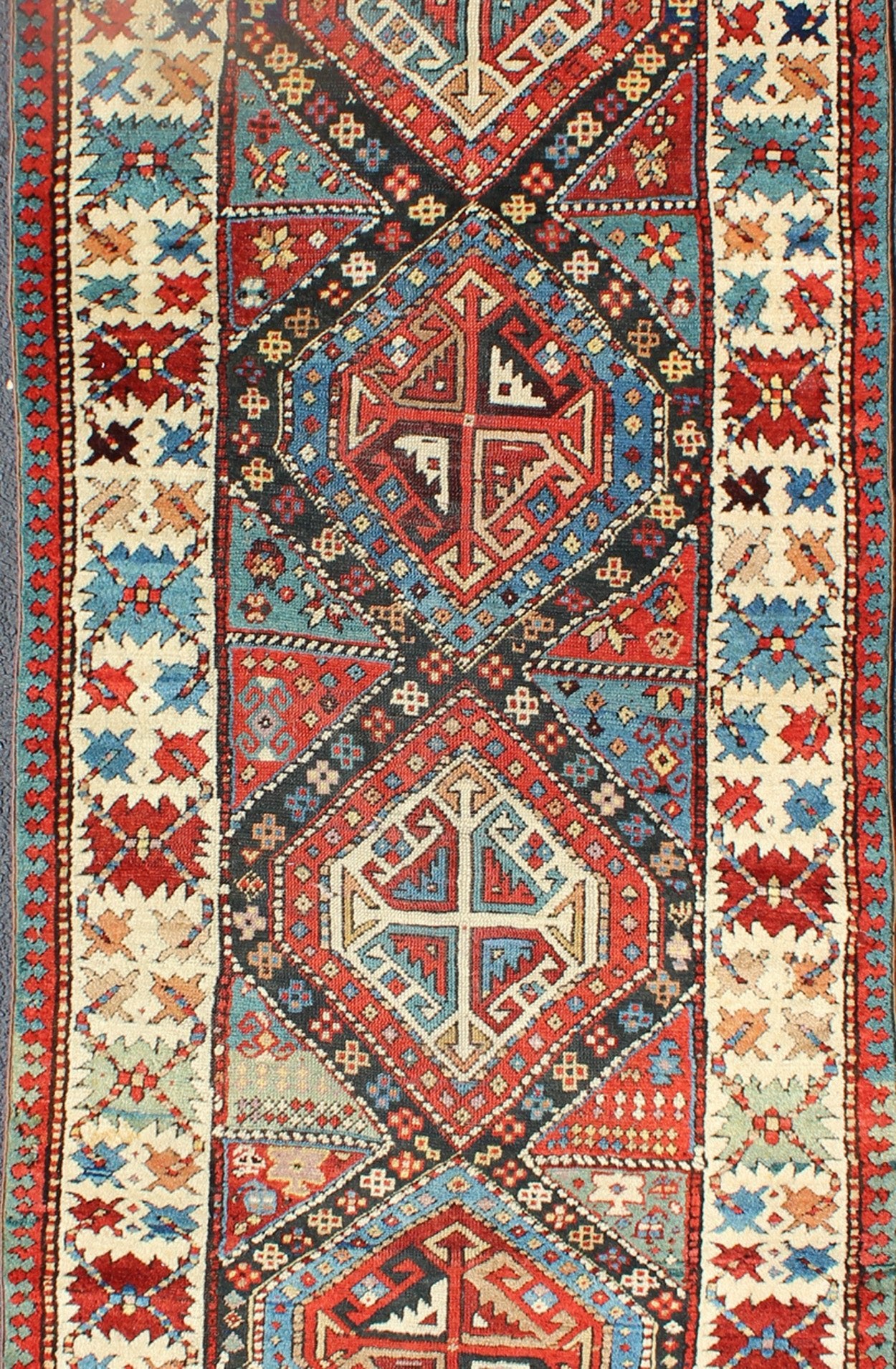 Antique Caucasian Kuba Rug This piece is an impeccable late 19th century Kuba rug with an indigo blue field beneath a geometric vinery trellis featuring bold polychrome medallions and stylized leaves. The ivory frame features repeating turtle mo... - Keivan Woven ArtsN15 - 0308 - 18Rug