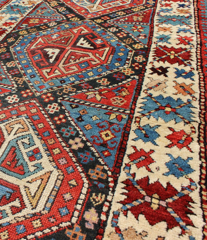 Antique Caucasian Kuba Rug This piece is an impeccable late 19th century Kuba rug with an indigo blue field beneath a geometric vinery trellis featuring bold polychrome medallions and stylized leaves. The ivory frame features repeating turtle mo... - Keivan Woven ArtsN15 - 0308 - 18Rug