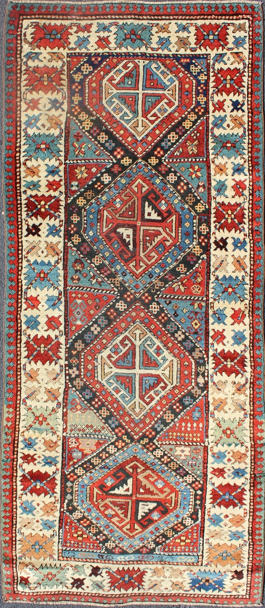 Antique Caucasian Kuba Rug This piece is an impeccable late 19th century Kuba rug with an indigo blue field beneath a geometric vinery trellis featuring bold polychrome medallions and stylized leaves. The ivory frame features repeating turtle mo... - Keivan Woven ArtsN15 - 0308 - 18Rug