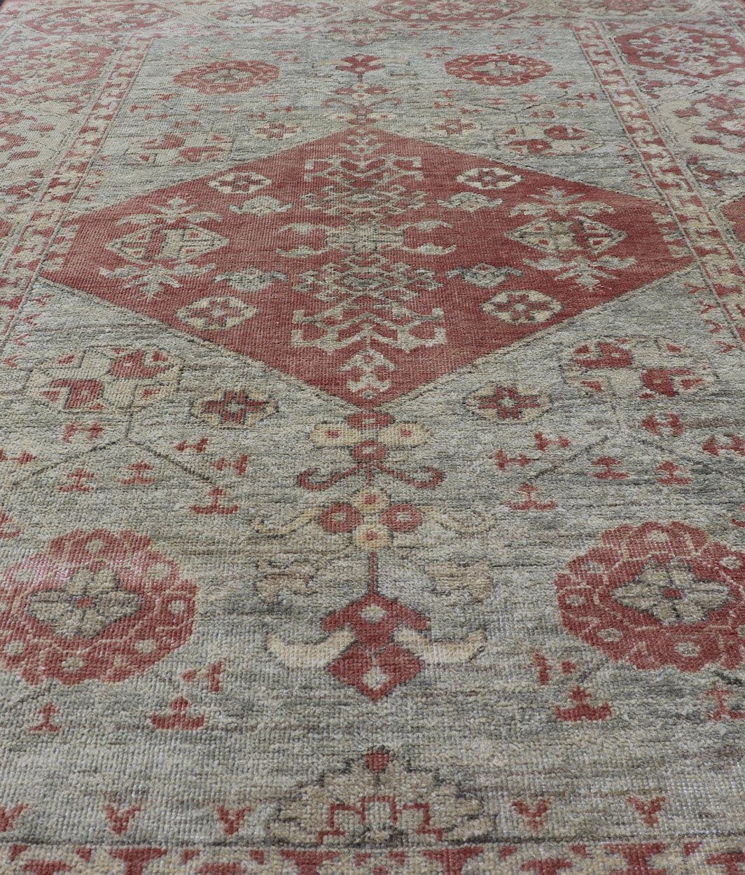 Modern Oushak Rug in Wool with Medallion Design in Light Blue and Coral This modern Indian Khotan rug has been hand - knotted in wool and features a floral medallion design rendered in light blue and coral tones. A complementary, multi - tiered bor... - Keivan Woven ArtsOB - 9580377 - 83230118 - 15502