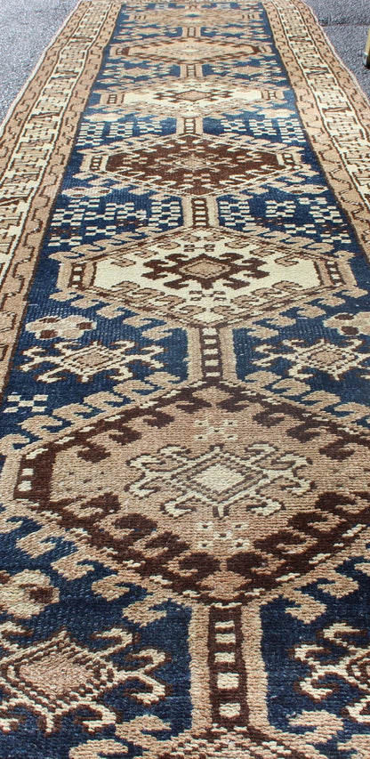 Antique Blue Tribal Karajeh Runner With Navy Blue, Brown and Earth Tones. Antique Persian Karajeh runner with stacked medallion in taupe, cream, blue, rug PRM - M522, country of origin / type: Iran / Karajeh , circa 1920 This antique Persian k... - Keivan Woven ArtsPRM - M522 - 12609