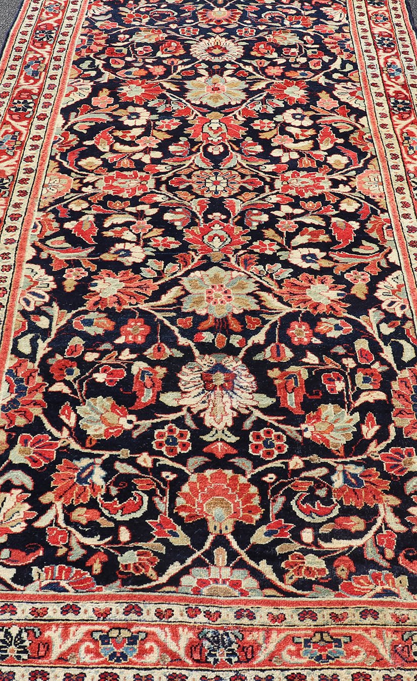 Antique Persian Gallery Runner with Floral Design in D. Blue & Jewel Tones. This lovely antique Gallery Mahal features a stunning all - over floral design set upon a dark blue background, and rendered in Ivory, Coral, varieties of Reds, Greens an... - Keivan Woven ArtsPTA - 21019 - 17376Rug