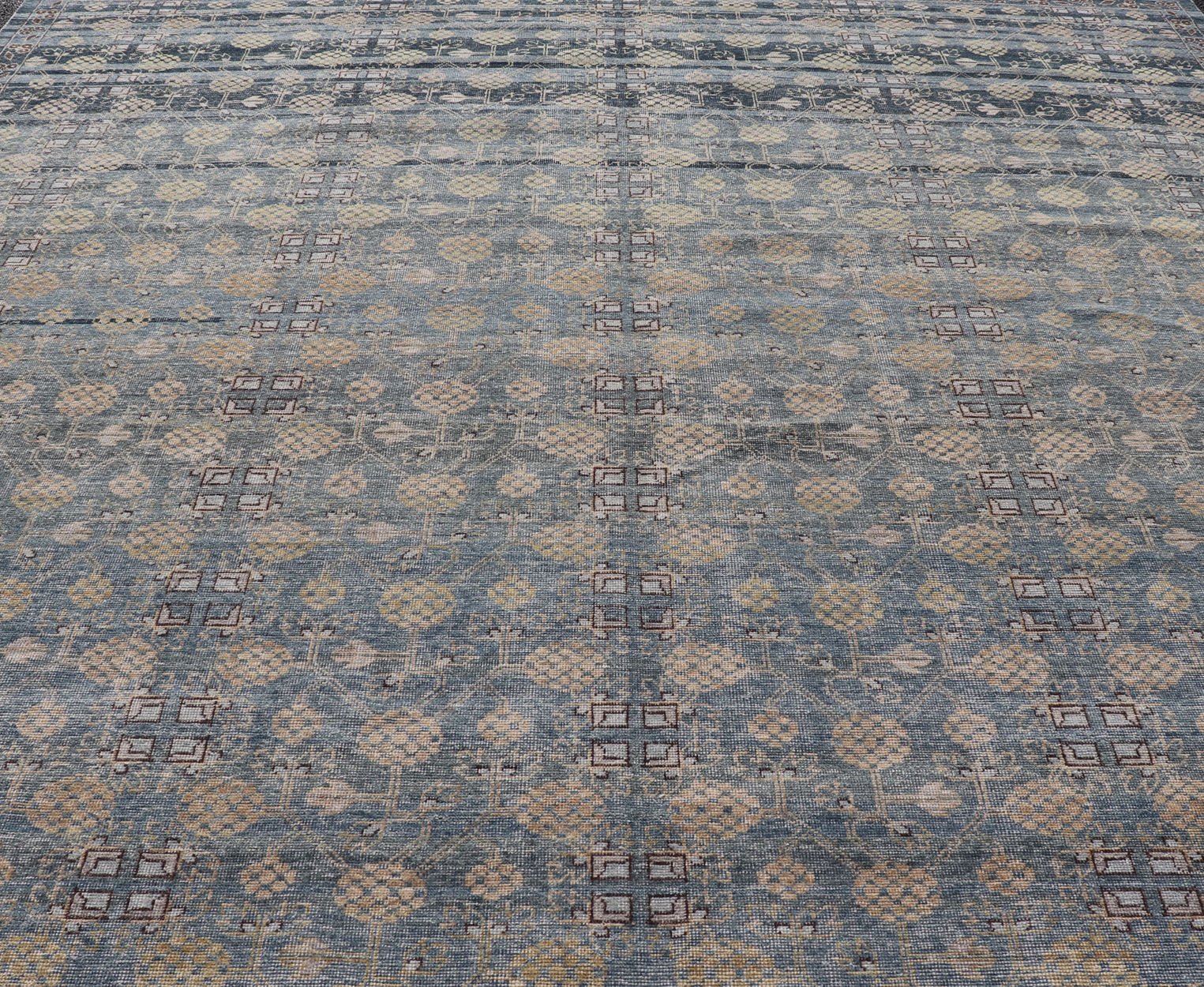Modern All - Over Tribal Motif Khotan Area Rug in Dark Blues, Brown and Cream. Country of Origin: Afghanistan; Type: Khotan; Design: Floral, All - Over; Keivan Woven Arts: rug/PUR - 42561. Measures: 12'1 x 15'1 This modern Khotan features a modern da... - Keivan Woven ArtsPUR - 42561 - GS - 1016 - 22620Rug