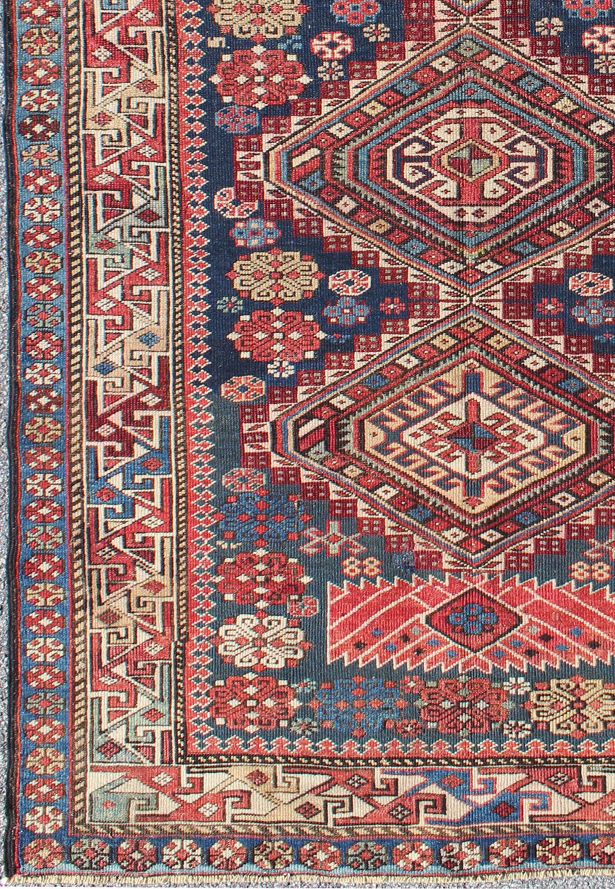 Antique Kazak Rug with In Multi Colors and Indigo Background. This antique, late 19th century Kazak rug from Russia displays three bold, geometric central medallions set on an indigo background and surrounded by multiple complementary geometric... - Keivan Woven ArtsS12 - 0517 - 3720Rug