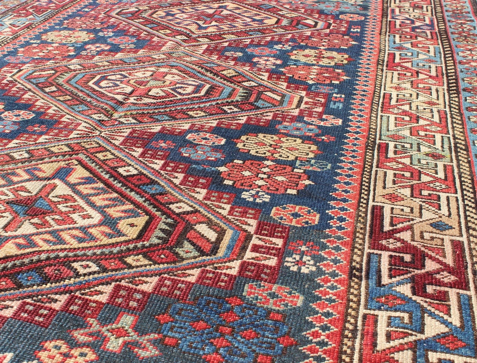 Antique Kazak Rug with In Multi Colors and Indigo Background. This antique, late 19th century Kazak rug from Russia displays three bold, geometric central medallions set on an indigo background and surrounded by multiple complementary geometric... - Keivan Woven ArtsS12 - 0517 - 3720Rug
